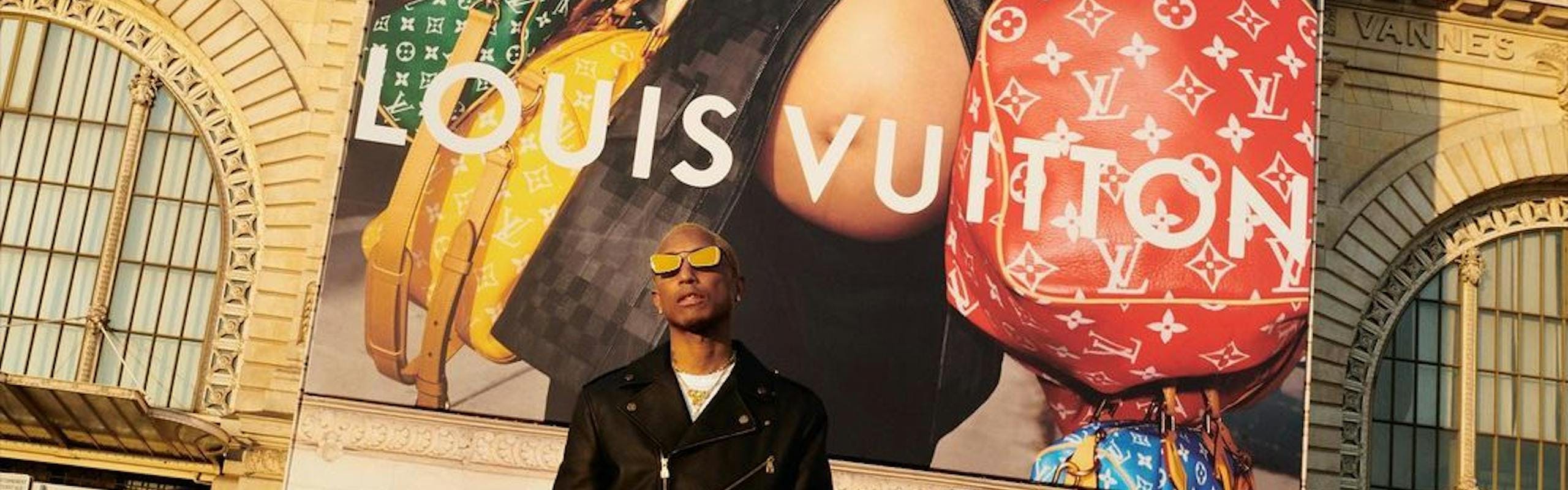 Pharrell Williams in front of a Louis Vuitton campaign.
