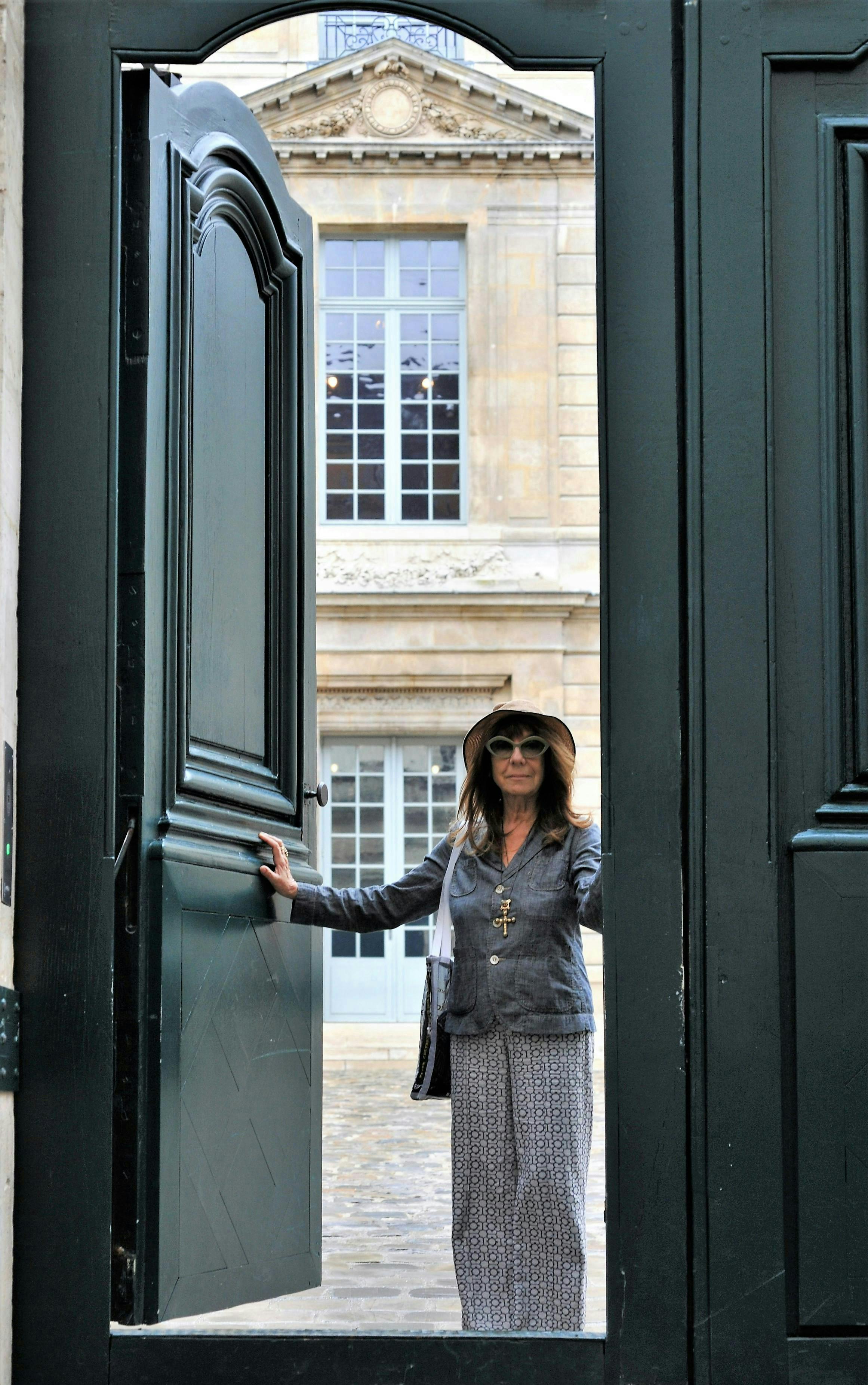 sophie calle standing in green door