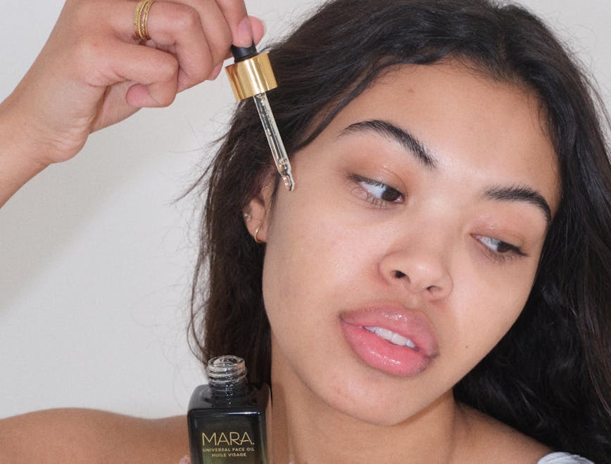 a woman applying mara beauty face oil