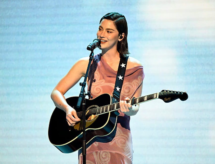 Gracie Abrams wearing a light pink velvet gown from Prada while performing on 'The Tonight Show Starring Jimmy Fallon.' Photo courtesy of Getty Images.
