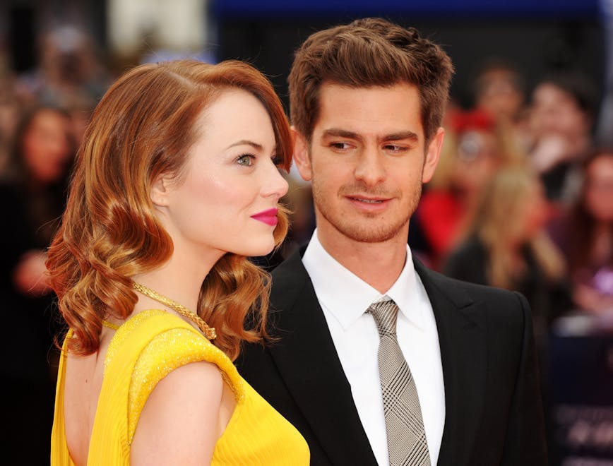 Andrew Garfield in a suit and tie and Emma Stone in a backless yellow dress at the premier of "The Amazing Spiderman 2"