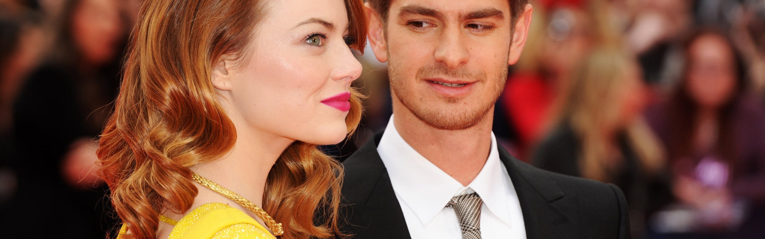 Andrew Garfield in a suit and tie and Emma Stone in a backless yellow dress at the premier of "The Amazing Spiderman 2"