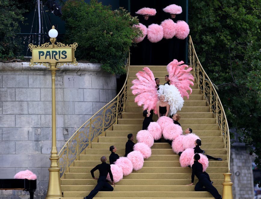 Lady Gaga performing a song on a staircase at the bank of the River Seine. Getty.
